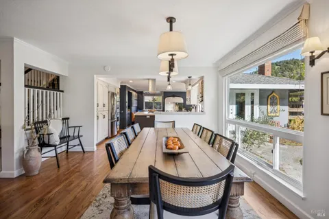 a living room with furniture a dining table and chairs with wooden floor