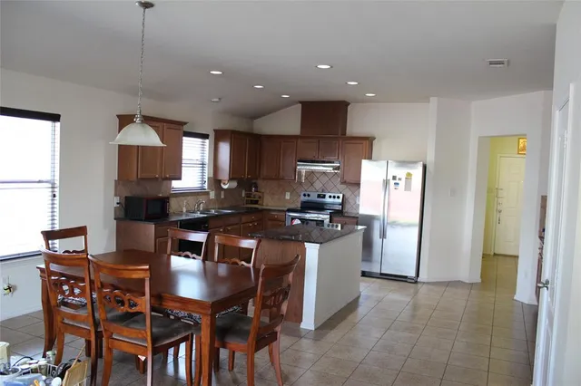a kitchen with a dining table cabinets and refrigerator