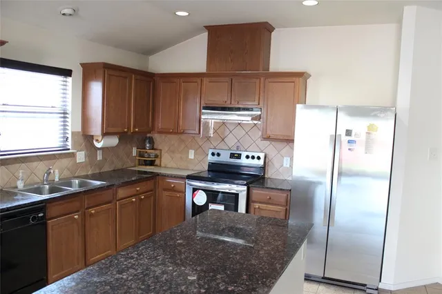 a kitchen with stainless steel appliances granite countertop a sink stove and refrigerator
