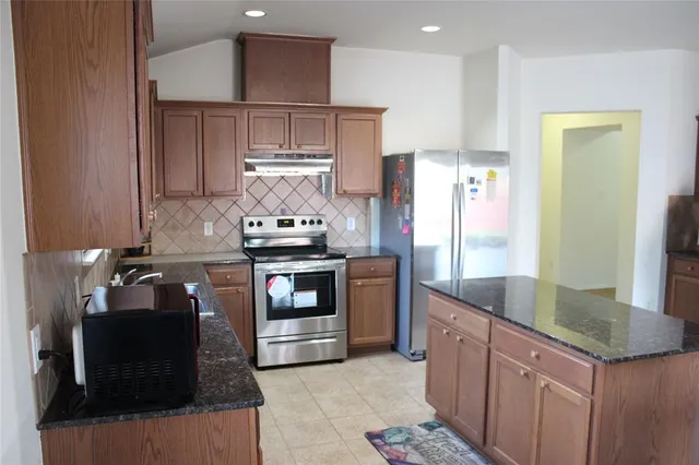 a kitchen with granite countertop a sink and a stove