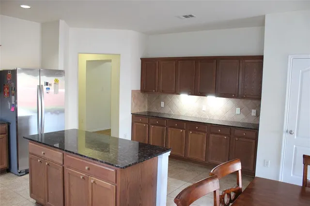 a kitchen with granite countertop a sink cabinets and stainless steel appliances