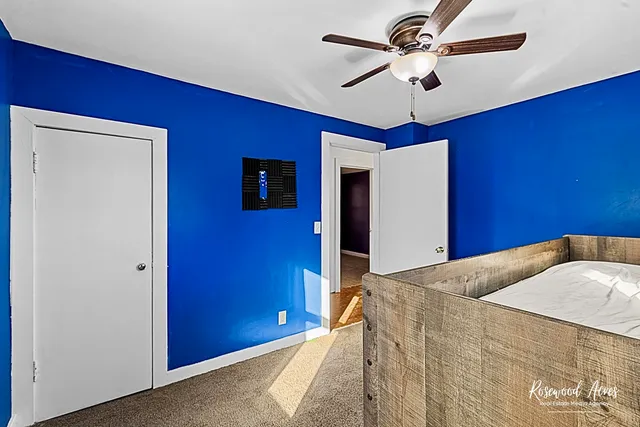 a bedroom with a bed and a ceiling fan