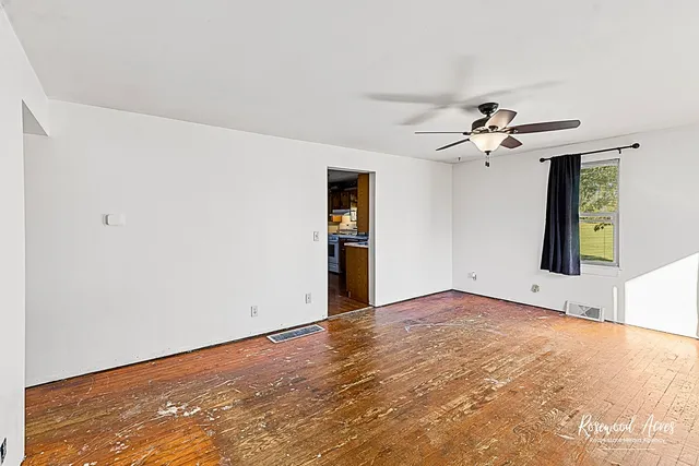 a view of empty room with wooden floor