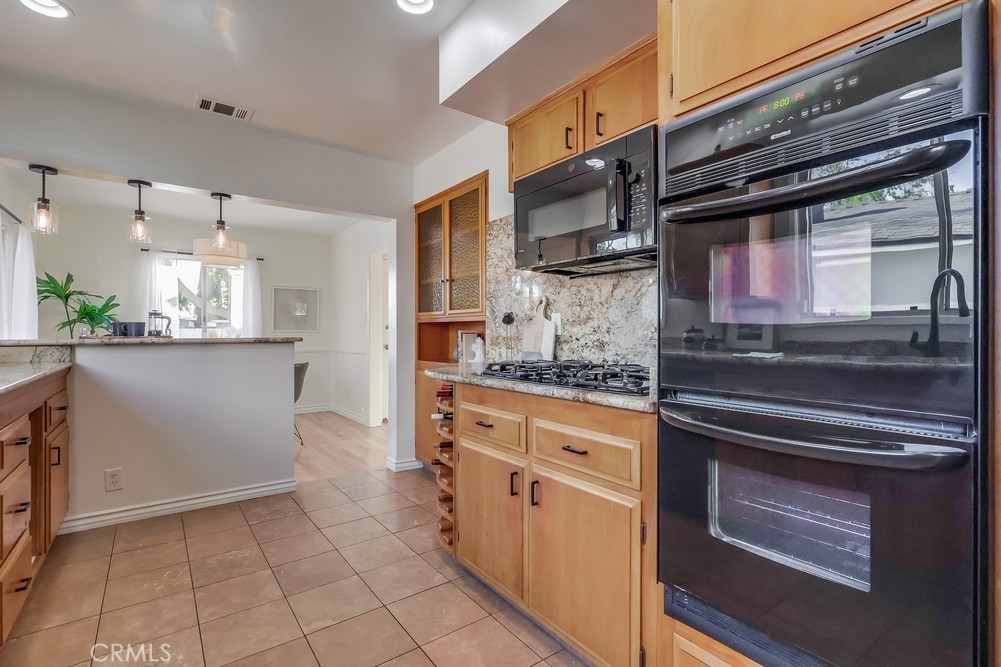 3562 North Studebaker Road Long Beach, CA 90808 - Photo 13 of 39 a kitchen with stainless steel appliances kitchen island granite countertop a stove microwave and cabinets