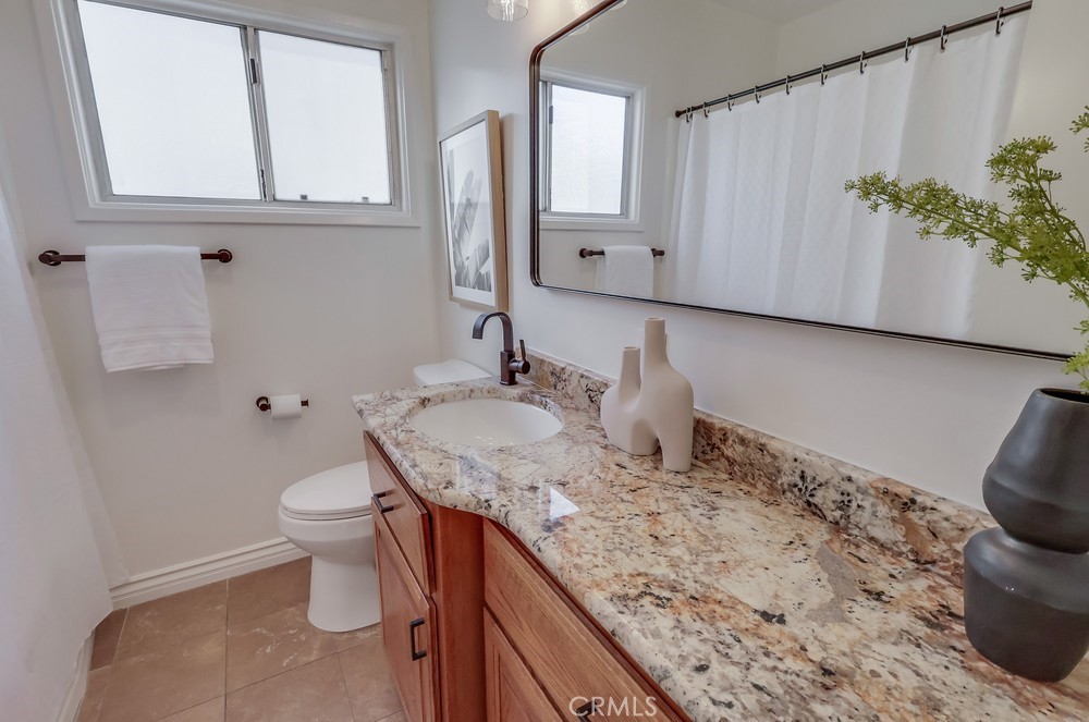 3562 North Studebaker Road Long Beach, CA 90808 - Photo 26 of 39 a bathroom with a granite countertop sink and a mirror