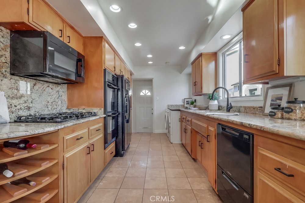 3562 North Studebaker Road Long Beach, CA 90808 - Photo 10 of 39 a kitchen with stainless steel appliances granite countertop a stove top oven a sink dishwasher and a microwave oven with cabinets
