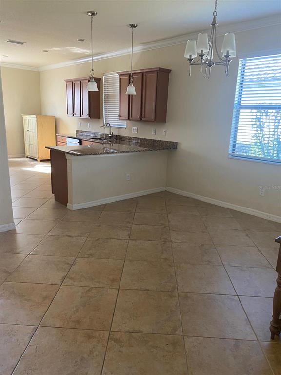 12792 Richezza Drive Venice, FL 34293 - Photo 7 of 24 a kitchen with kitchen island granite countertop a sink a counter top space cabinets and stainless steel appliances