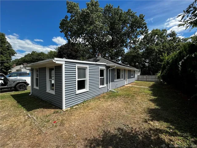 a front view of house with yard and trees in the background