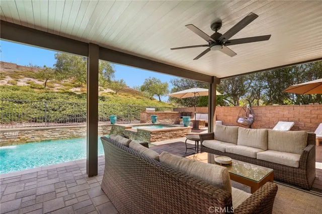 a view of a patio with a table and chairs under an umbrella with a barbeque grill and plants