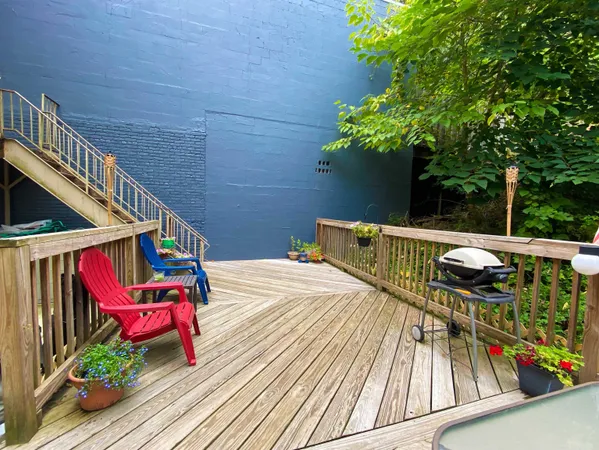 a balcony with wooden floor table and chairs