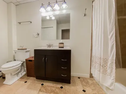a bathroom with a sink vanity mirror and toilet
