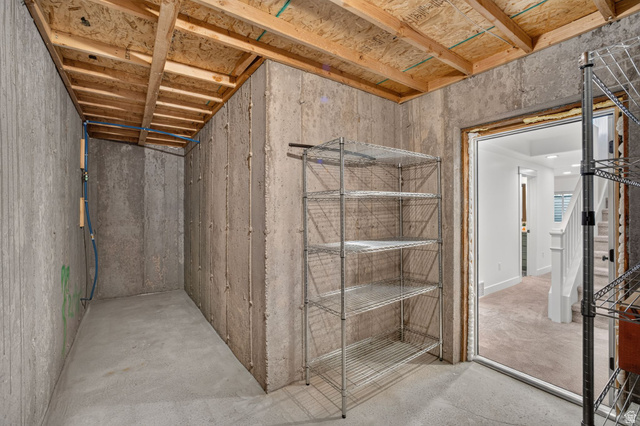 6536 West Muirfield Road Highland, UT 84003 - Photo 36 of 48 Unfinished basement area featuring concrete walls, concrete flooring, exposed wooden ceiling joists, and visible utility lines