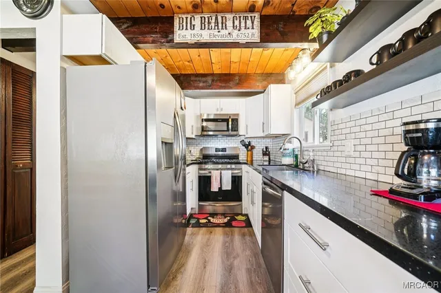 a kitchen with stainless steel appliances granite countertop a refrigerator and a stove