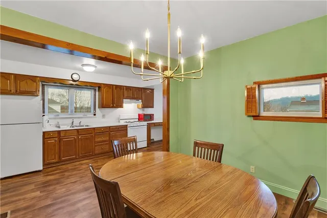 a kitchen with a table chairs refrigerator and microwave