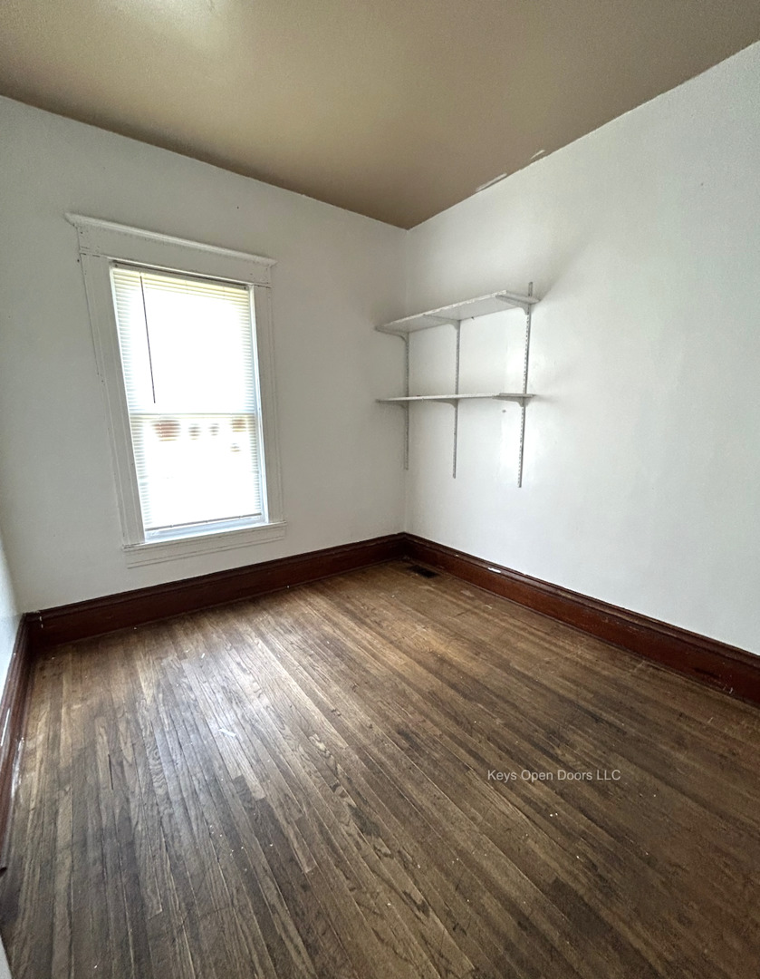 509 Fifth Street Aurora, IL 60505 - Photo 13 of 14 an empty room with wooden floor and windows