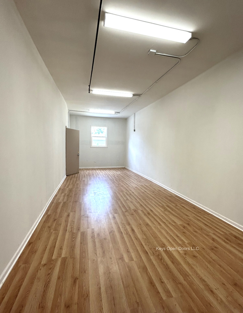 509 Fifth Street Aurora, IL 60505 - Photo 3 of 14 an empty room with wooden floor and windows