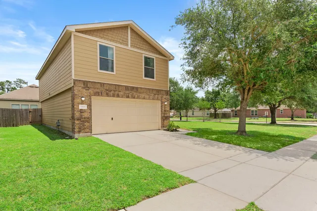 a front view of a house with a yard and garage