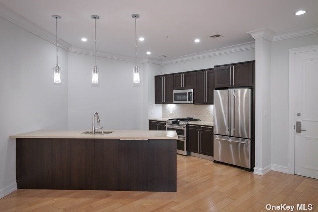 a kitchen with kitchen island stainless steel appliances a sink and a refrigerator