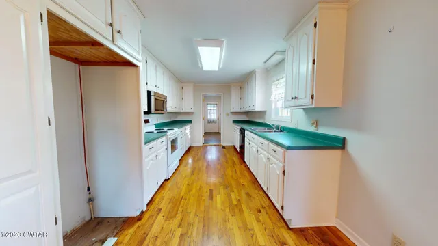 a kitchen with kitchen island granite countertop a sink a counter top space and stainless steel appliances
