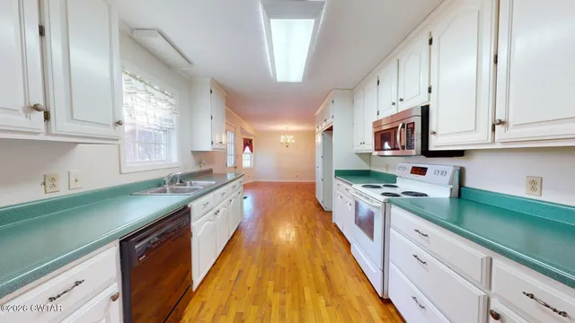 a large kitchen with stainless steel appliances granite countertop a lot of counter space and a sink