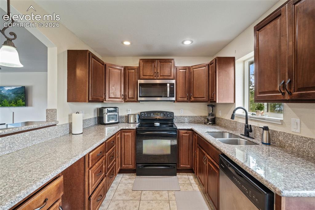 125 Diamond E Road Fountain, CO 80817 - Photo 13 of 43 a kitchen with stainless steel appliances granite countertop a sink stove microwave and cabinets