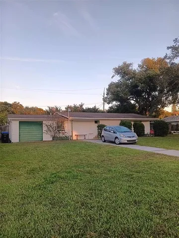 a view of a house with a big yard and potted plants