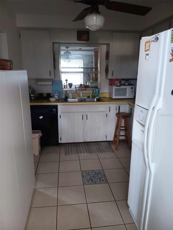 4245 Edgewater Drive Orlando, FL 32804 - Photo 15 of 44 a kitchen with stainless steel appliances a refrigerator a sink a stove a microwave and cabinets