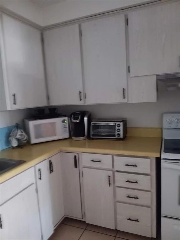 4245 Edgewater Drive Orlando, FL 32804 - Photo 20 of 44 a kitchen with granite countertop white cabinets and white appliances