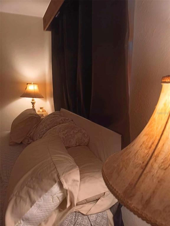 4245 Edgewater Drive Orlando, FL 32804 - Photo 31 of 44 a bed sitting in a bedroom next to a window