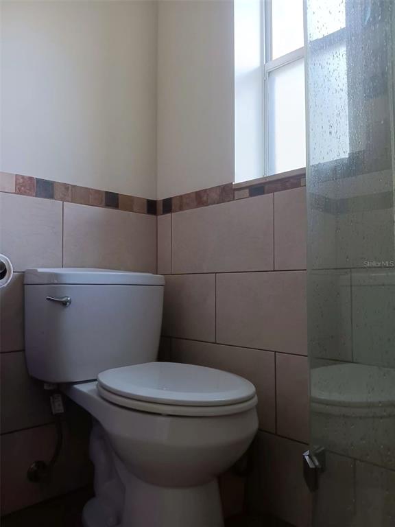 4245 Edgewater Drive Orlando, FL 32804 - Photo 38 of 44 a white toilet sitting next to a bathroom sink and a window