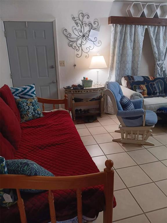 4245 Edgewater Drive Orlando, FL 32804 - Photo 9 of 44 a bedroom with a bed and a chair