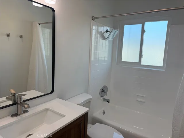 a bathroom with a bathtub a window and a shower