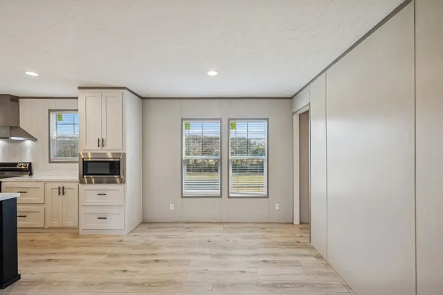 a large room with a window and stainless steel appliances