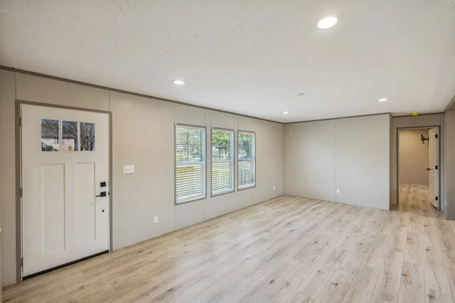 a view of living room with kitchen island stainless steel appliances wooden floor and living room view
