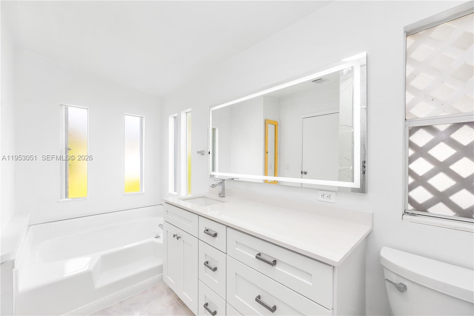 5611 Southwest 32nd Terrace Dania Beach, FL 33312 - Photo 20 of 29 a bathroom with a granite countertop sink mirror and a bathtub