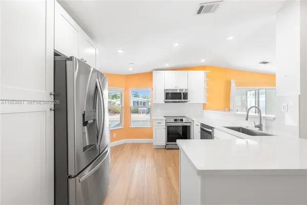 a kitchen with stainless steel appliances a refrigerator and a sink