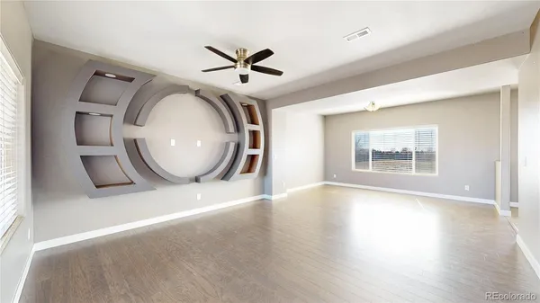 a view of a livingroom with wooden floor and a large window