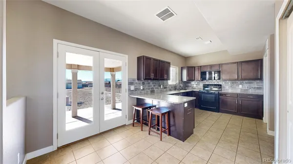 a kitchen with stainless steel appliances granite countertop a stove top oven a sink a counter space and cabinets