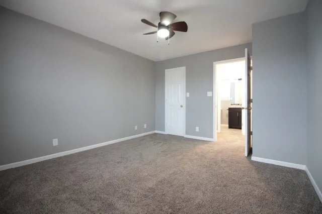 a view of empty room with a ceiling fan and window