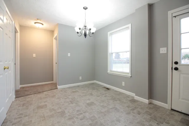 an empty room with windows and chandelier