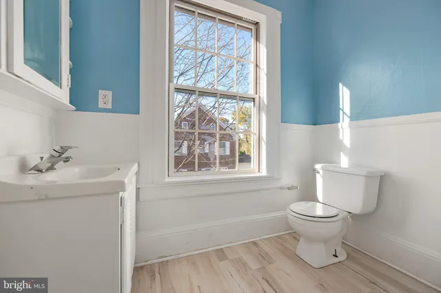 a bathroom with a sink toilet and window