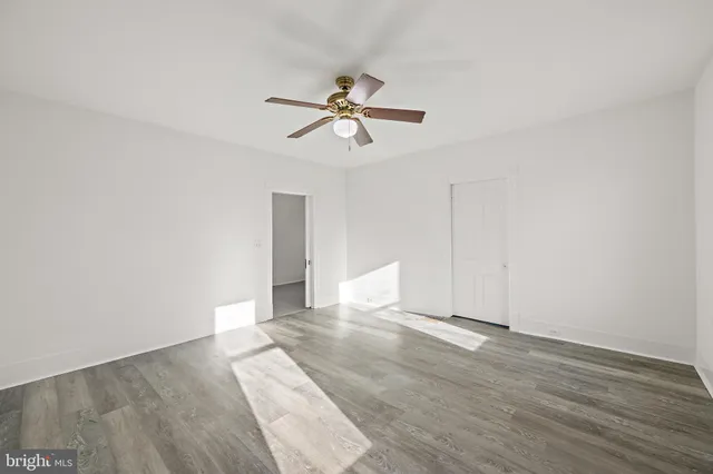 a view of a room with wooden floor and ceiling fan