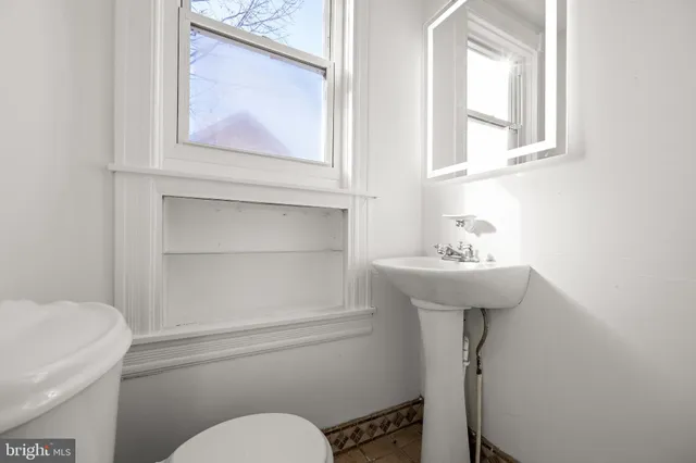 a bathroom with a toilet sink and mirror