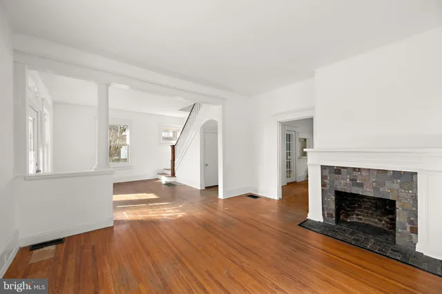 a view of empty room with wooden floor and fireplace