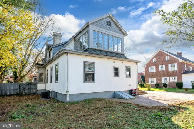 a view of a house with a big yard and large tree