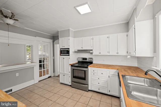 a kitchen with white cabinets and stainless steel appliances