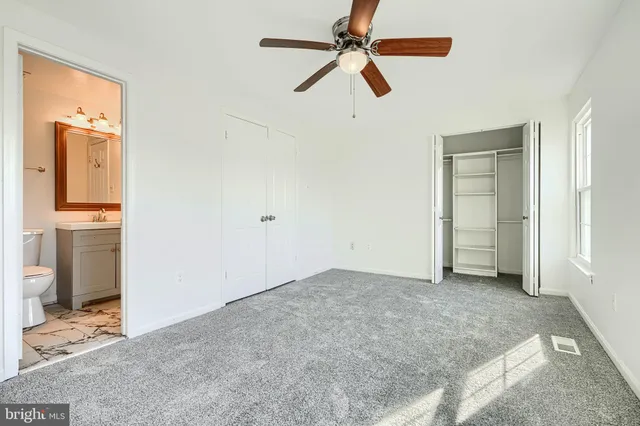 an empty room with a window and a fan