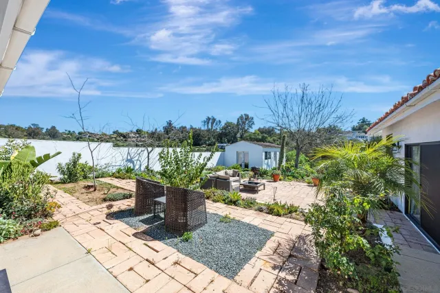 a view of a patio with table and chairs potted plants