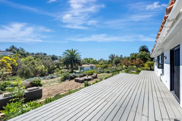 a view of a patio with couches table and chairs and potted plants