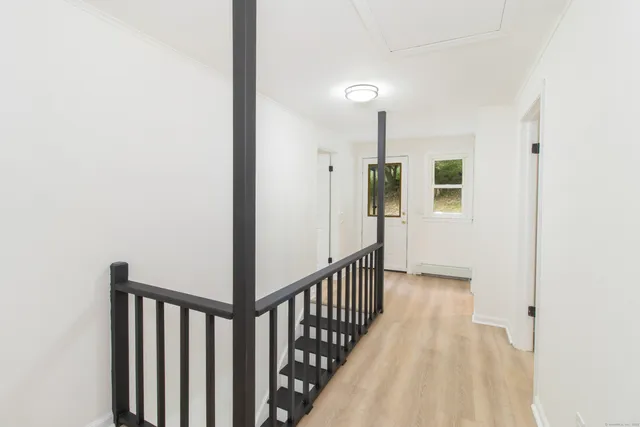 a view of a hallway with wooden floor and staircase